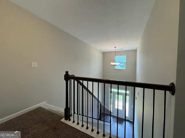 an empty room with windows and ceiling fan