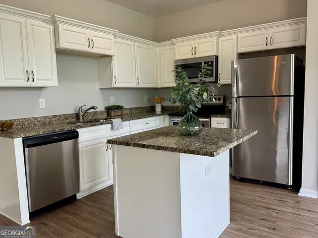 a kitchen with stainless steel appliances granite countertop a refrigerator sink and cabinets