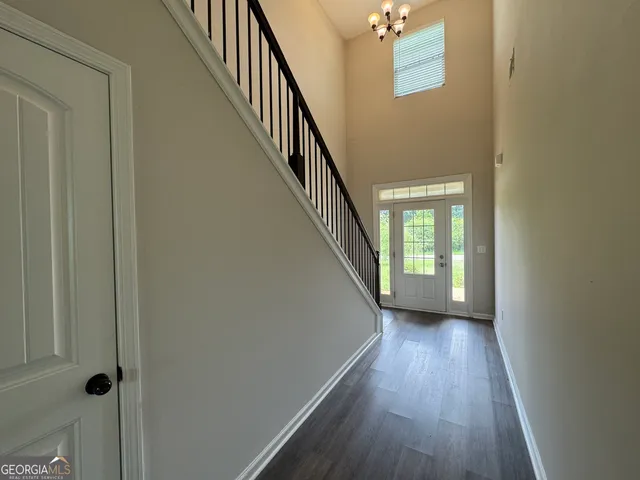 a view of a hallway with wooden floor and staircase