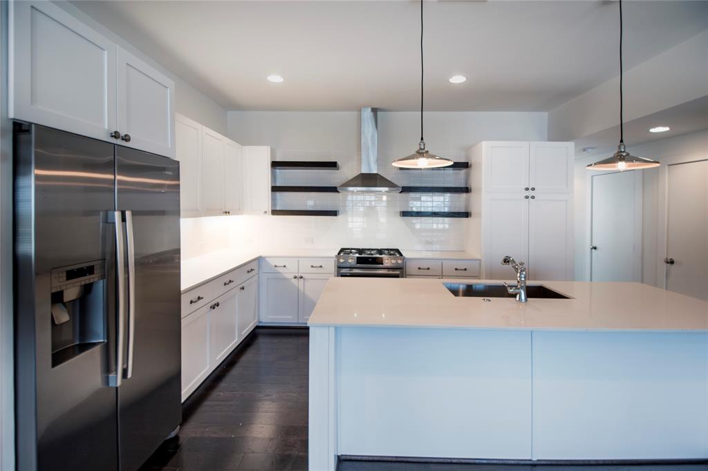 a kitchen with stainless steel appliances a refrigerator sink and wooden floor