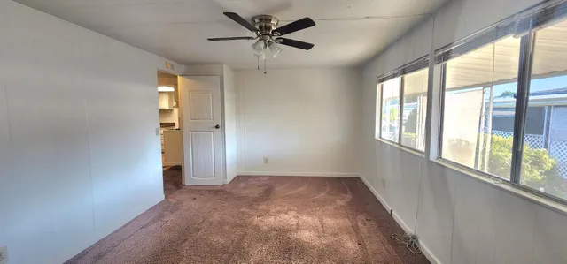 a view of a livingroom with a ceiling fan and window