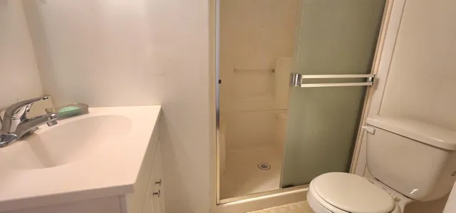 a bathroom with a sink a toilet and shower