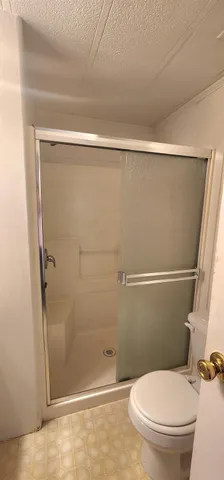 a bathroom with a toilet and a shower