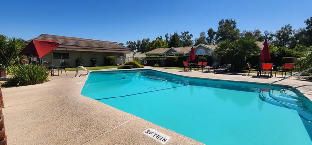 a view of a chairs and table on the patio and a swimming pool