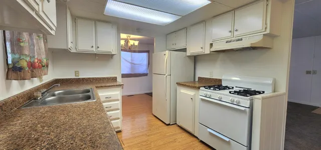 a kitchen with stainless steel appliances granite countertop a sink stove and cabinets