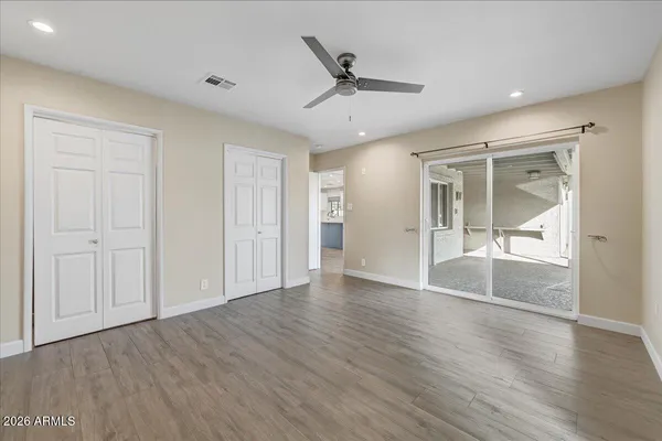an empty room with wooden floor and windows