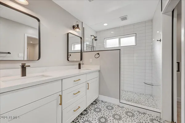 a bathroom with a double vanity sink mirror and shower