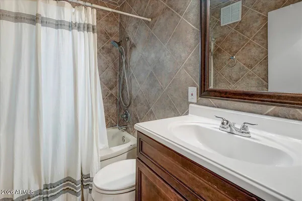 a bathroom with a sink a toilet and shower curtain