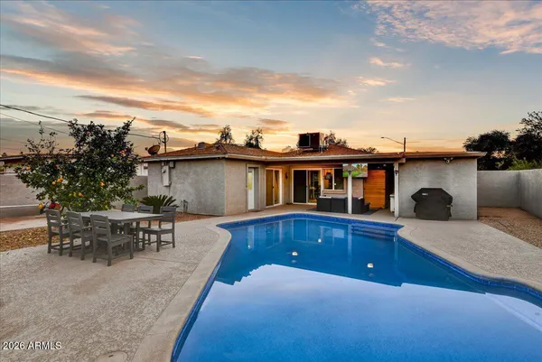 a view of a house with swimming pool and sitting area