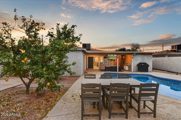 a backyard of a house with table and chairs