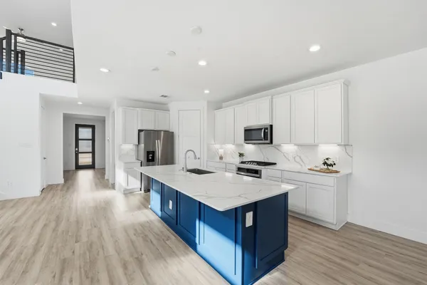 a large kitchen with stainless steel appliances granite countertop a lot of counter space and wooden floor