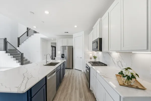 a kitchen with granite countertop a sink a stove and refrigerator
