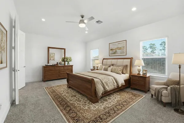 a spacious bedroom with a bed a couch and dresser