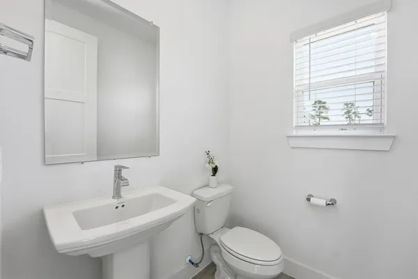 a bathroom with a sink a toilet and a mirror