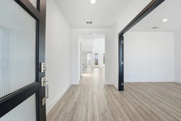 a view of a hallway with wooden floor
