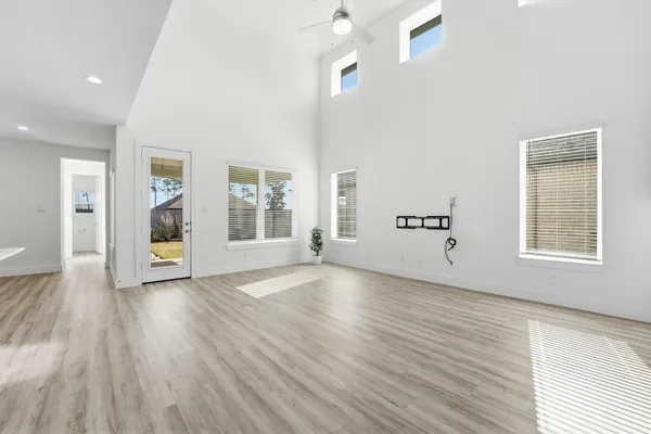 an empty room with wooden floor and windows