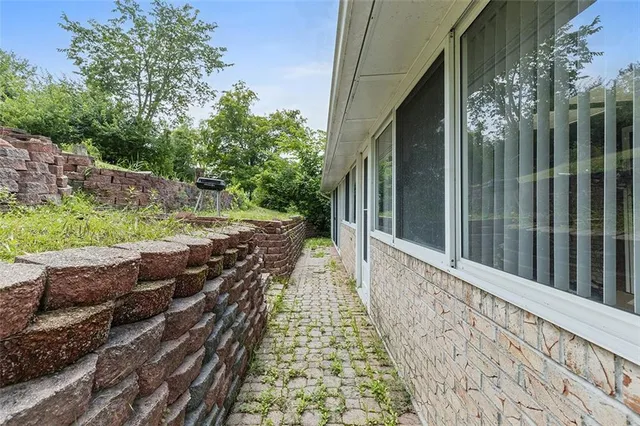 a backyard of a house with large trees and plants