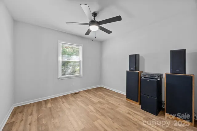 a view of a livingroom with wooden floor and a ceiling fan