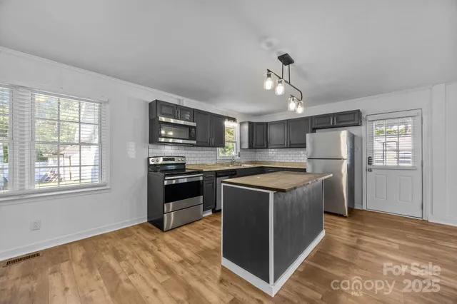 a kitchen with stainless steel appliances granite countertop a stove and a refrigerator