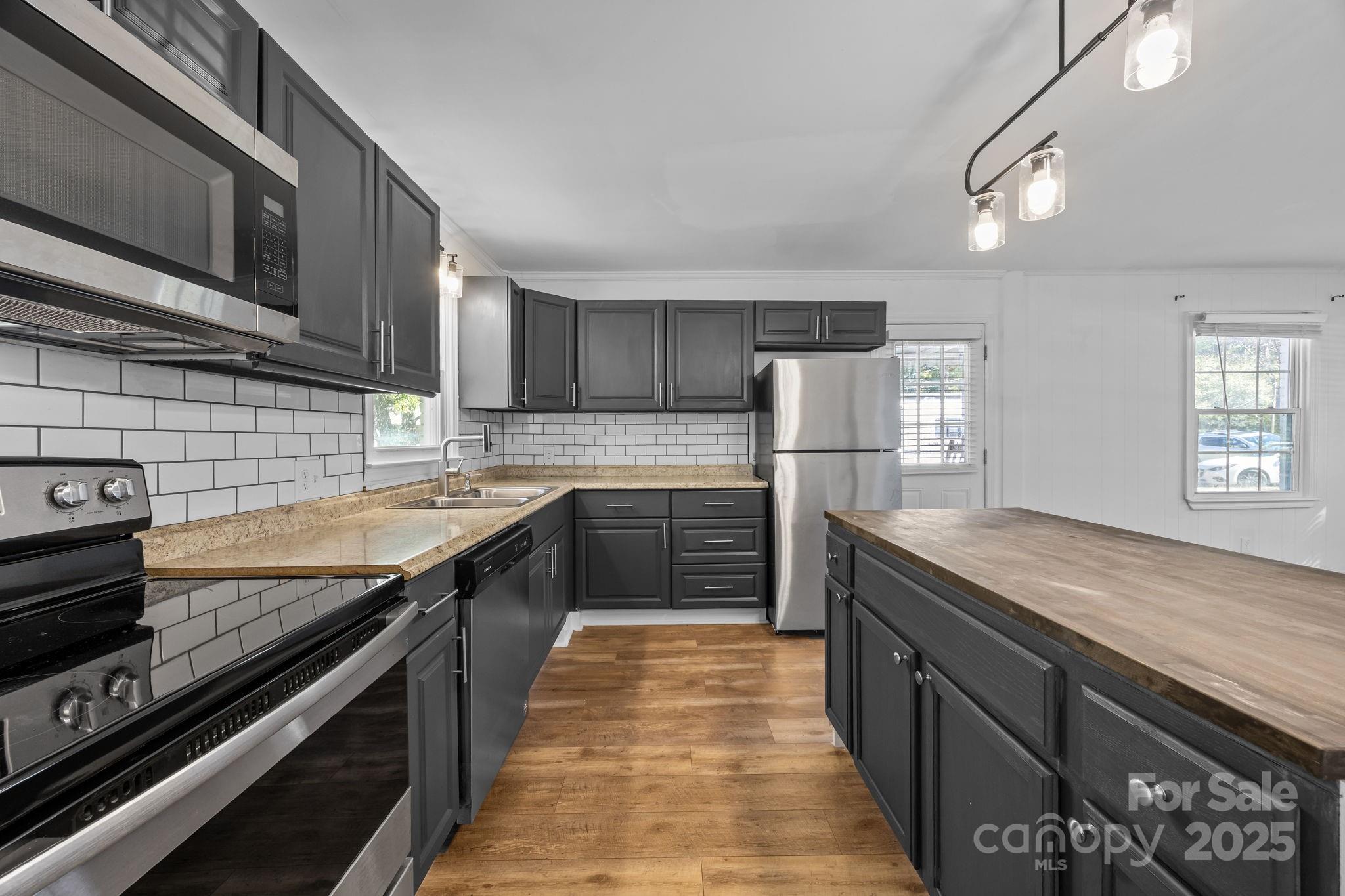 976 10 Oaks Drive Lancaster, SC 29720 - Photo 6 of 24 a kitchen with stainless steel appliances granite countertop wooden cabinets sink and stove