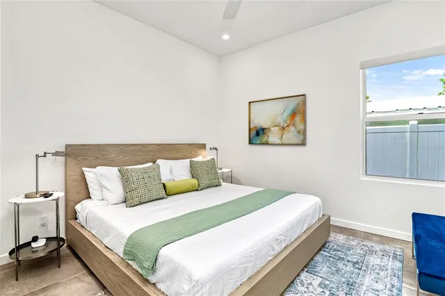 a bedroom with a bed and a painting on the wall