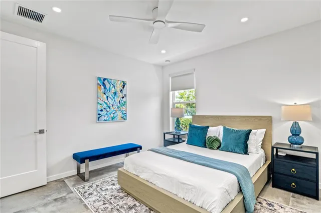 a bedroom with a bed and a painting on the wall