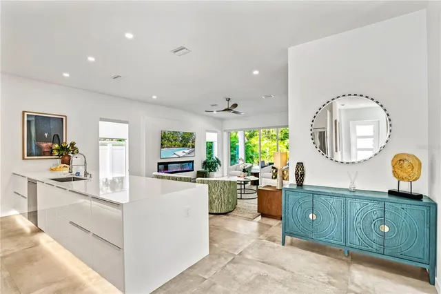 a kitchen with a dining table chairs stove and white cabinets