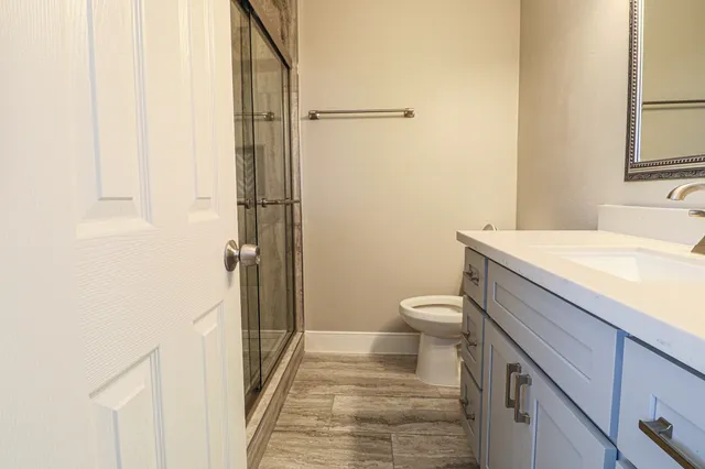 a bathroom with a sink a toilet and shower