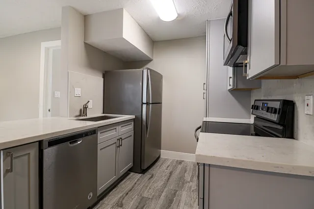 a kitchen with stainless steel appliances granite countertop a sink stove and refrigerator