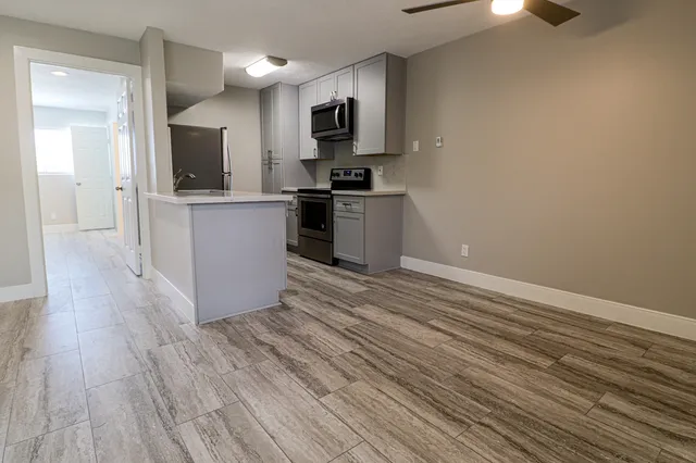 a kitchen with a refrigerator and a stove top oven