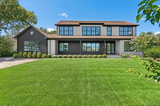a front view of a house with a yard and trees