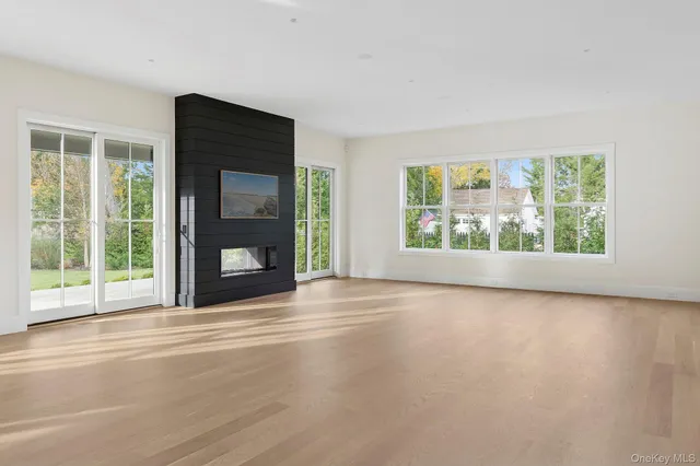 a view of an empty room with a fireplace and a window