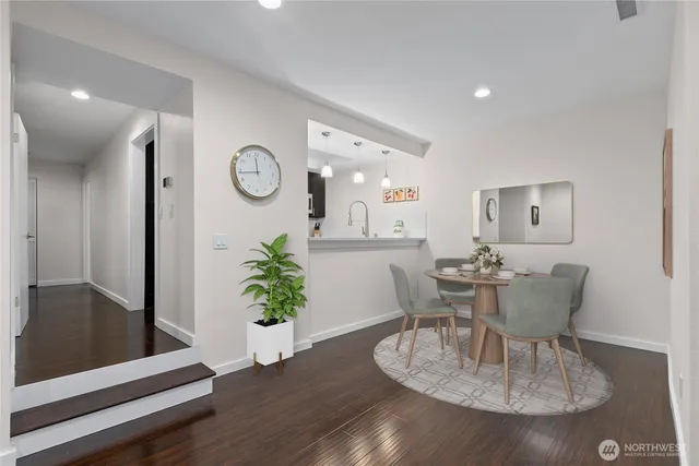 a dining room with furniture potted plants and wooden floor