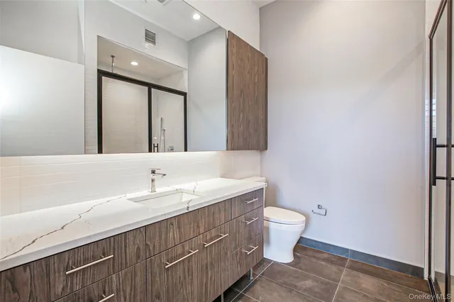 a bathroom with a double vanity sink mirror and toilet
