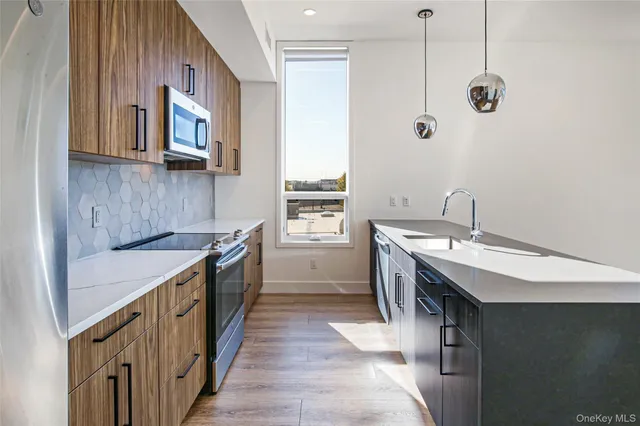 a kitchen with stainless steel appliances a sink stove and cabinets