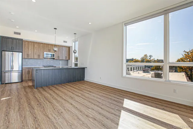 a view of kitchen with wooden floor and electronic appliances