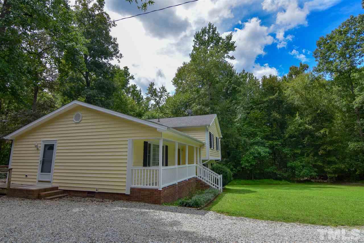 6354 Helena Moriah Road Rougemont, NC 27572 - Photo 6 of 21 a view of a white house next to a yard with large trees