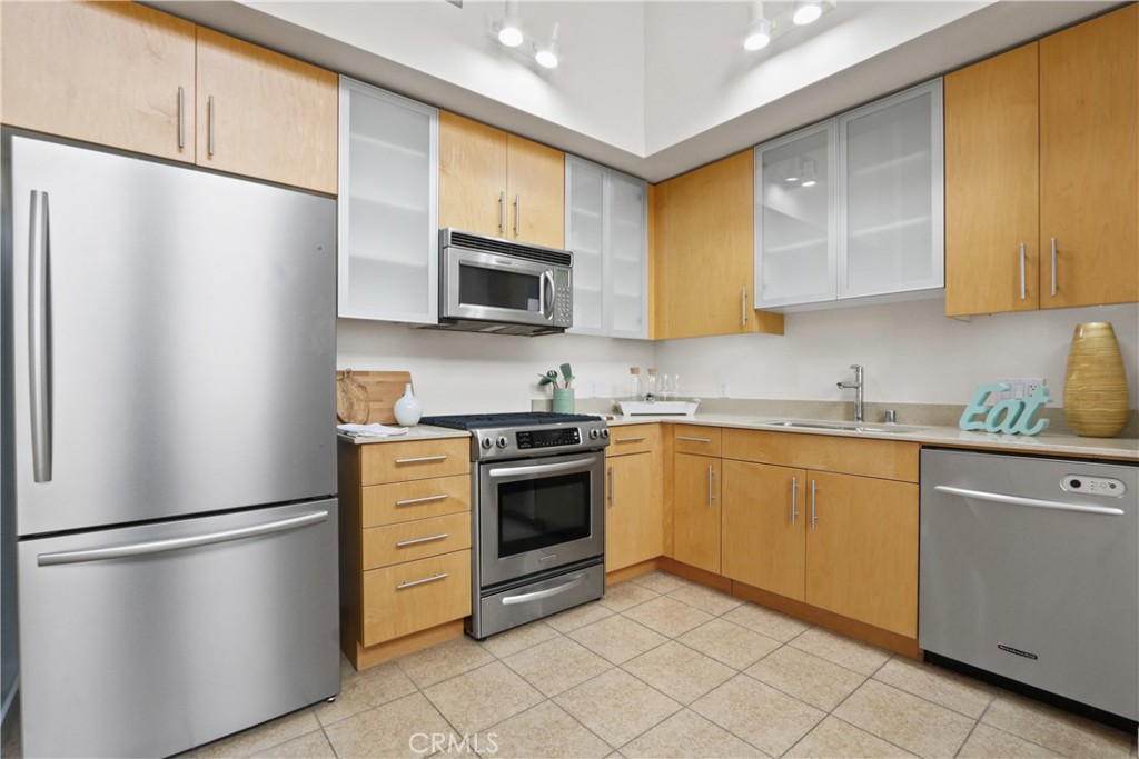 133 The Promenade North, Unit 402 Long Beach, CA 90802 - Photo 5 of 26 a kitchen with stainless steel appliances a refrigerator sink and microwave