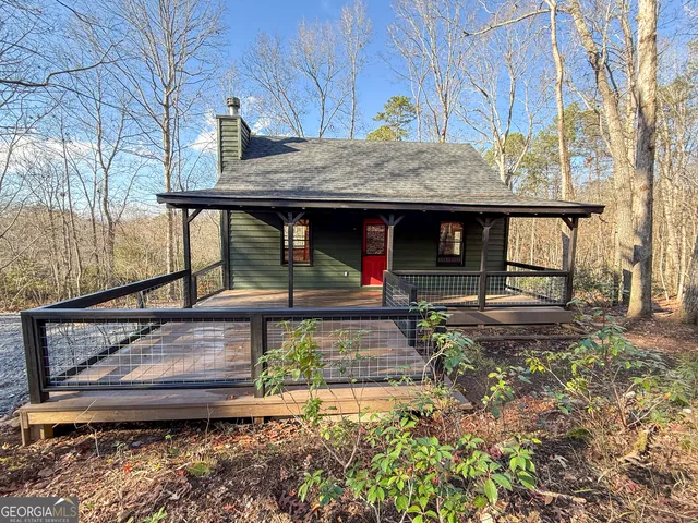 a view of a house with large windows and a small yard