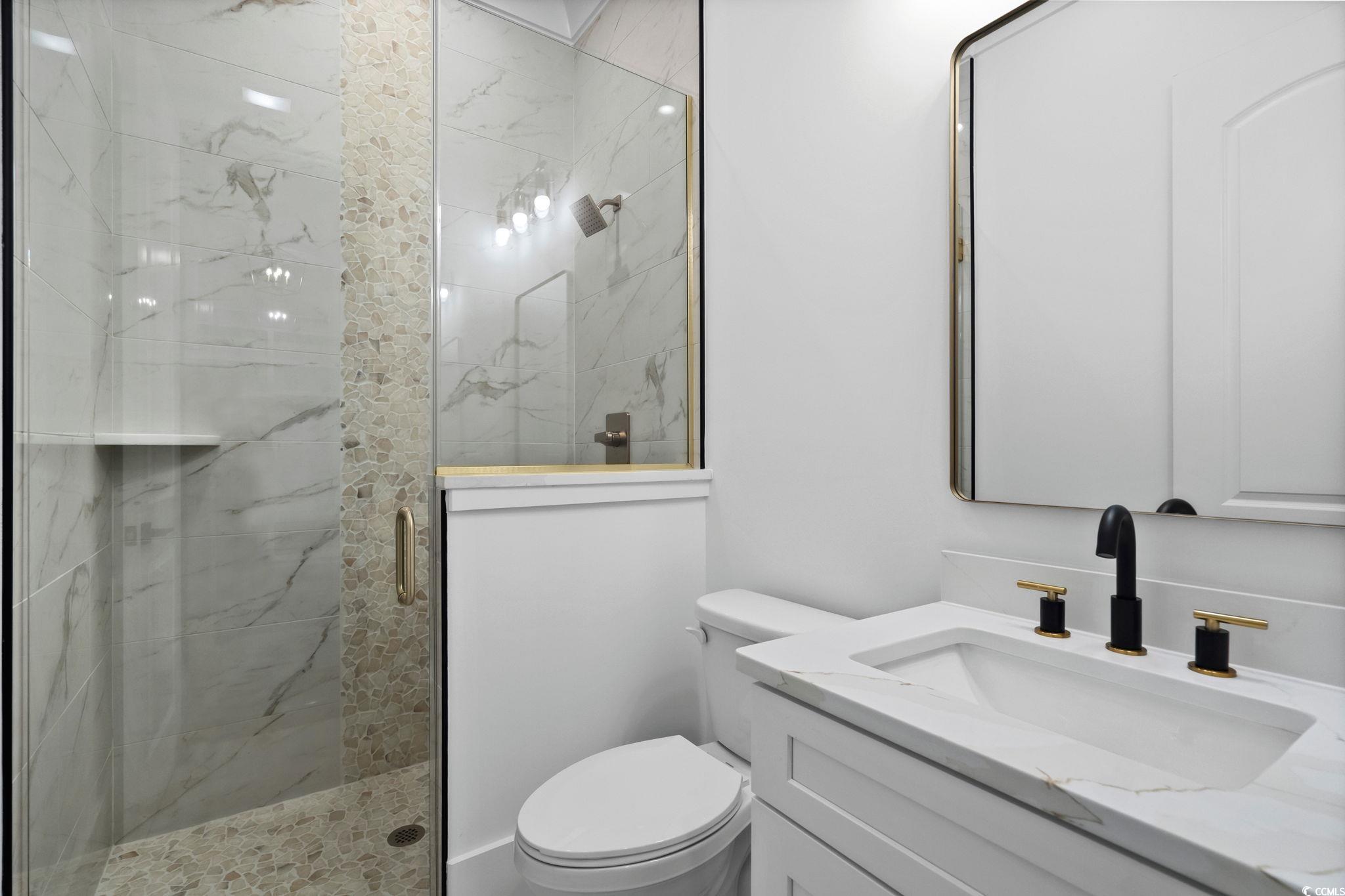 311 73rd Avenue North Myrtle Beach, SC 29572 - Photo 27 of 40 Bathroom with a marble finish shower and vanity