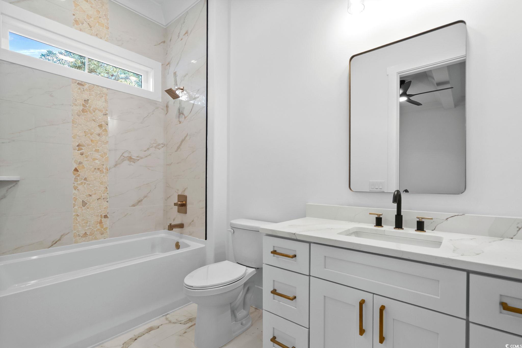 311 73rd Avenue North Myrtle Beach, SC 29572 - Photo 28 of 40 Full bath featuring light marble finish flooring, shower / bathtub combination, and vanity