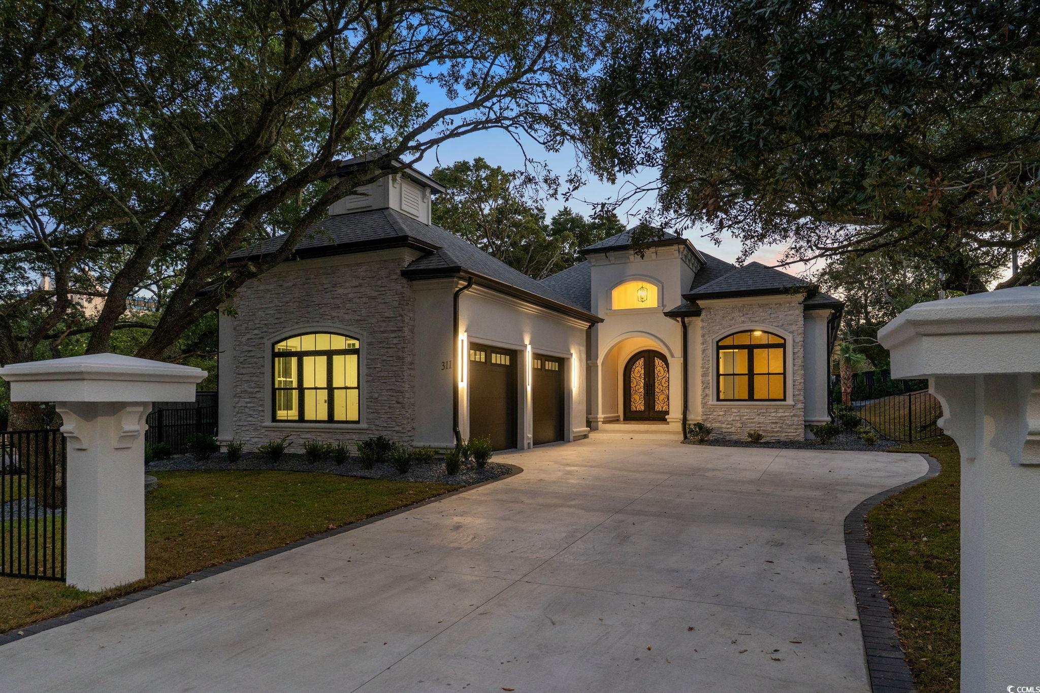 311 73rd Avenue North Myrtle Beach, SC 29572 - Photo 33 of 40 Mediterranean / spanish-style house with stone siding, driveway, a garage, and stucco siding