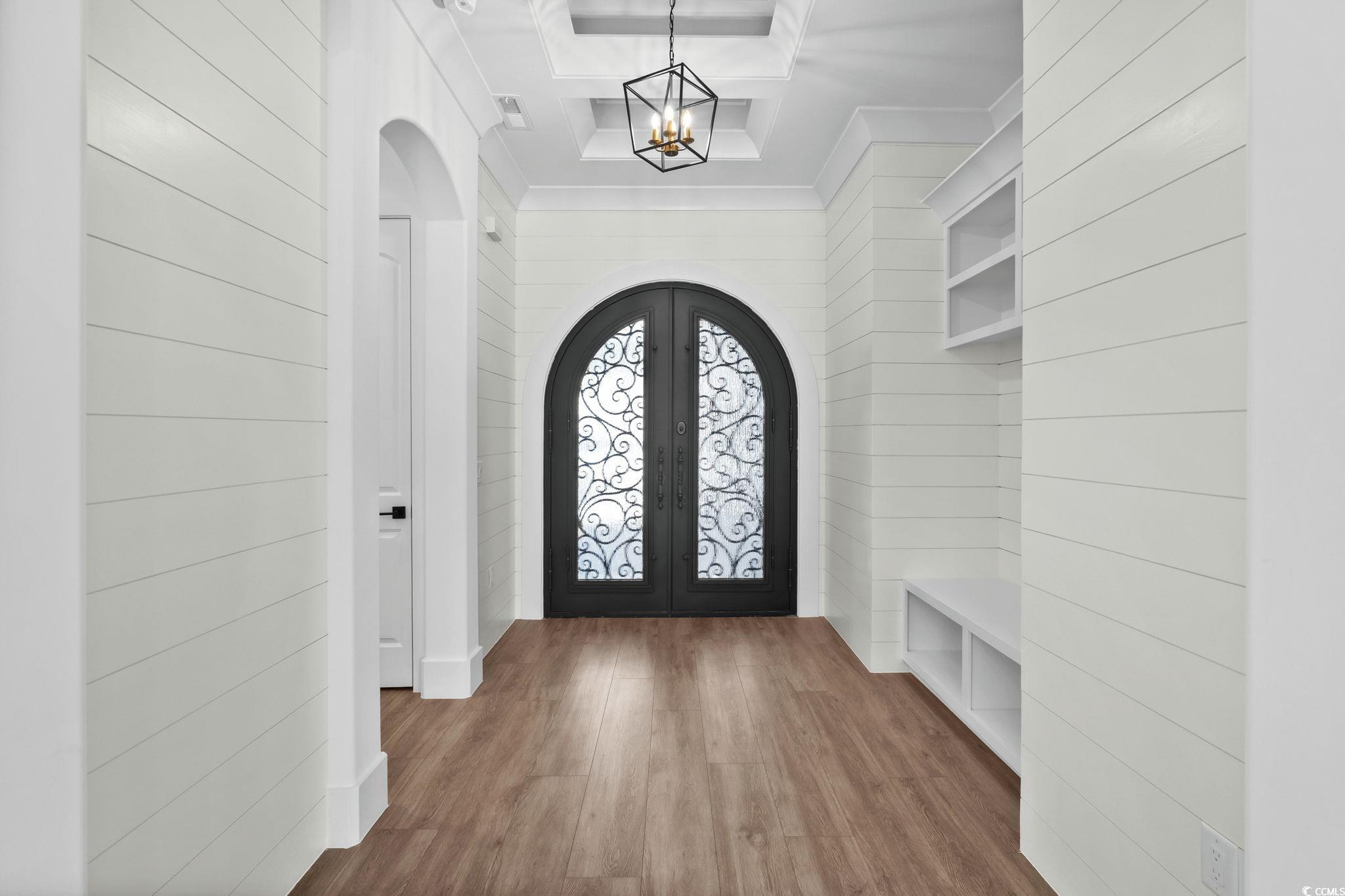 311 73rd Avenue North Myrtle Beach, SC 29572 - Photo 9 of 40 Mudroom with wood finished floors, arched walkways, a tray ceiling, a chandelier, and french doors