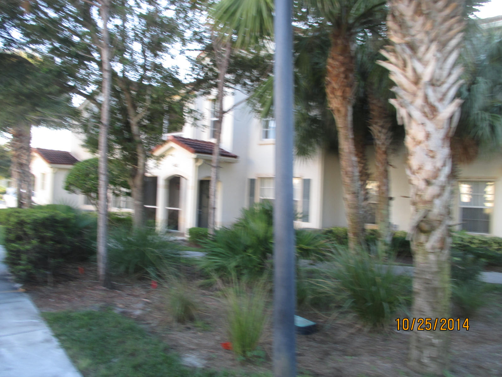 541 Southeast Prescott Place, Unit 541 Stuart, FL 34994 - Photo 20 of 20 a view of a white house next to a yard with potted plants and trees