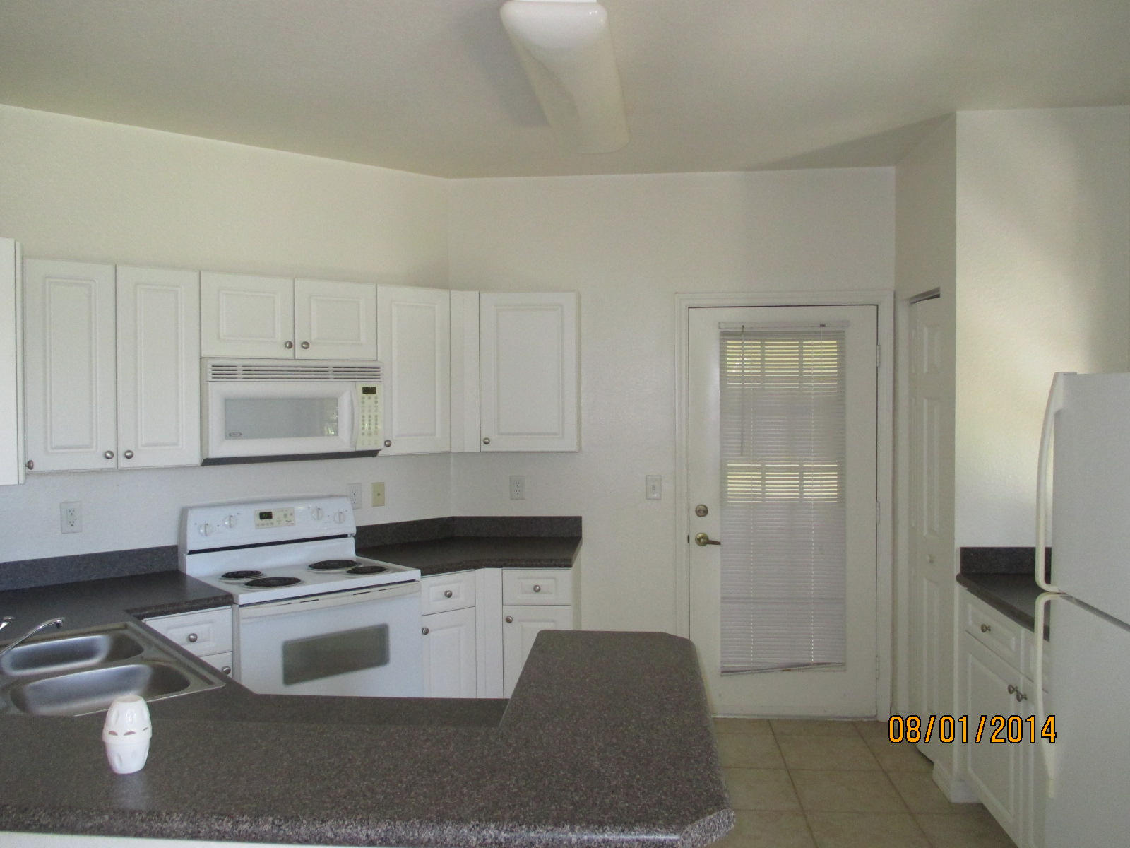 541 Southeast Prescott Place, Unit 541 Stuart, FL 34994 - Photo 8 of 20 a kitchen with a refrigerator stove and white cabinets