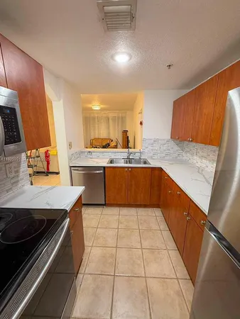 a kitchen with stainless steel appliances kitchen island sink refrigerator and stove