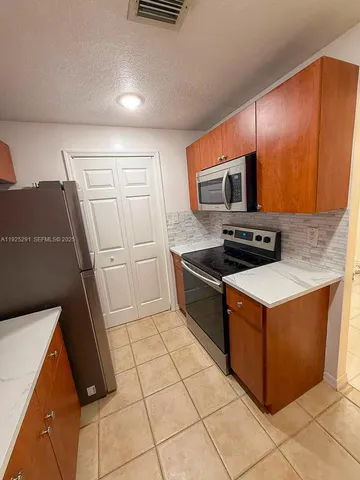 a kitchen with granite countertop sink and cabinets