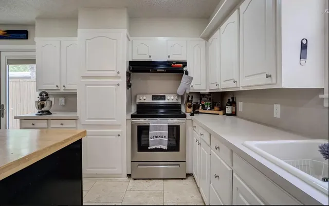 a kitchen with white cabinets and white appliances