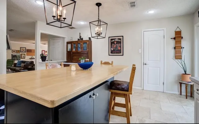 a kitchen with a table chairs and a chandelier