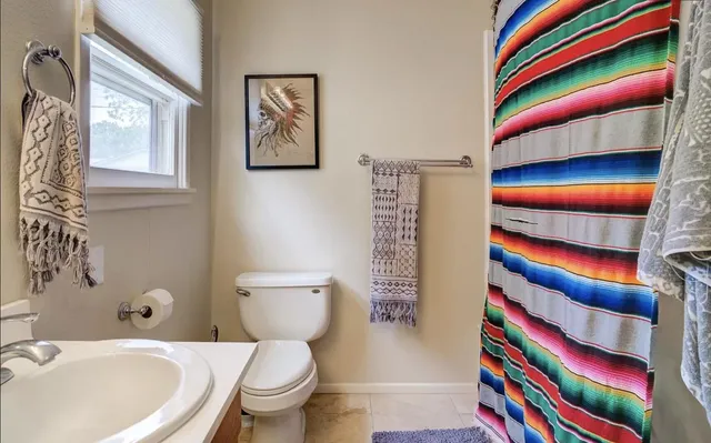 a bathroom with a sink a toilet and a shower curtain